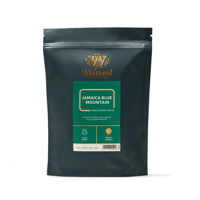 A dark green bag of Whittard Jamaica Blue Mountain Coffee, featuring gold and green labeling and labeled as a light roast with notes of molasses and apple. This exquisite hand-picked coffee is grown in volcanic regions famous for producing the finest Jamaica Blue Mountain Coffee.