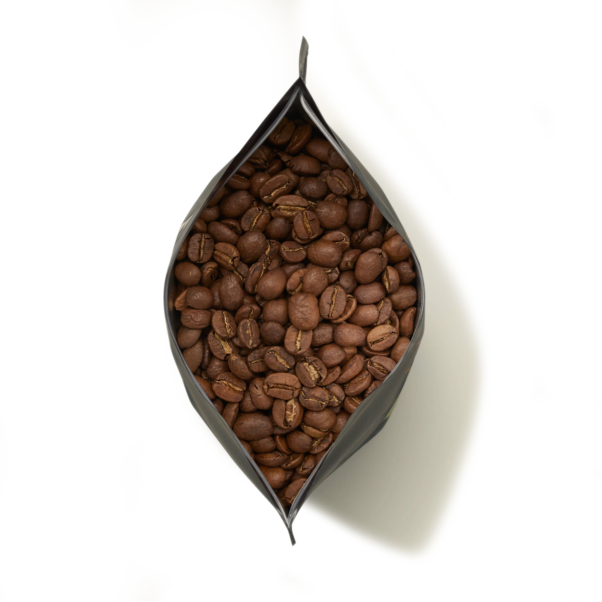 An open black bag of Jamaica Blue Mountain Coffee, filled with whole, hand-picked beans and viewed from above on a white background.