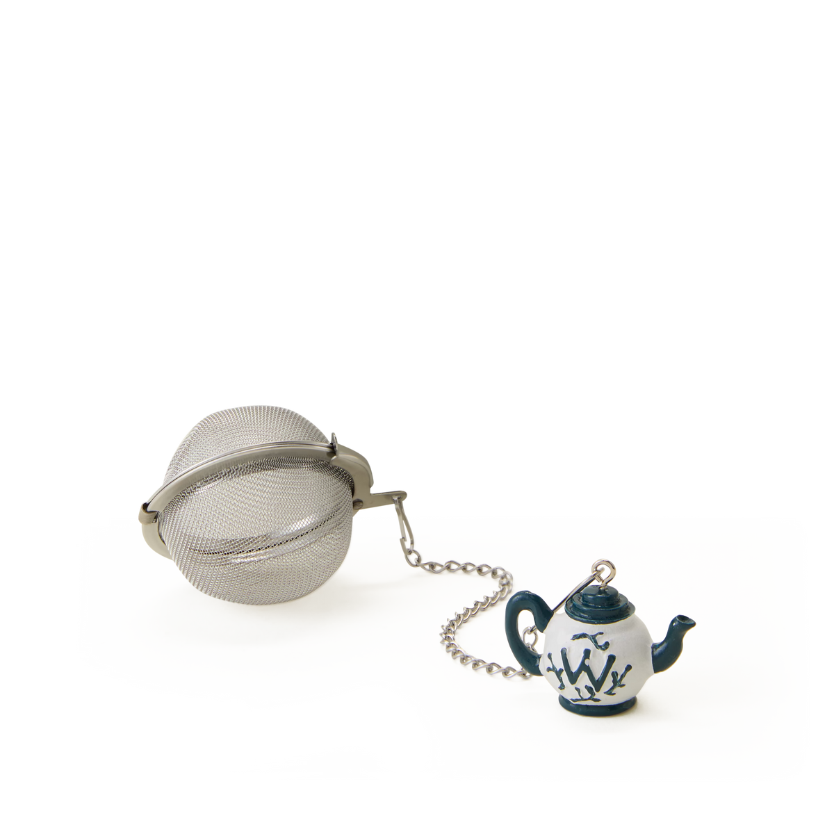 A metal tea infuser ball is attached to a small ceramic teapot charm with blue designs, all set against a plain white background.
