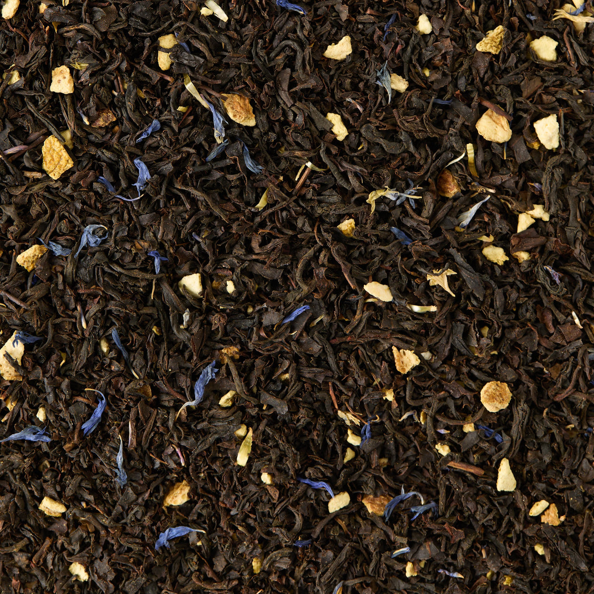 A close-up, textured background featuring Earl Grey Loose Leaf Tea, showcasing black tea leaves blended with small pieces of dried orange peel and scattered blue cornflower petals, all accented by the distinctive aroma of bergamot.