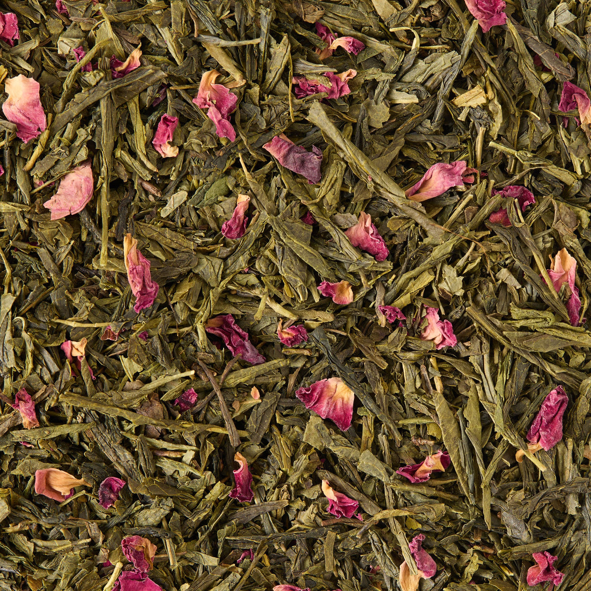 Cherry Blossom Loose Leaf Tea features a blend of sencha green tea leaves and scattered dried pink rose petals, creating a vibrant and textured appearance.