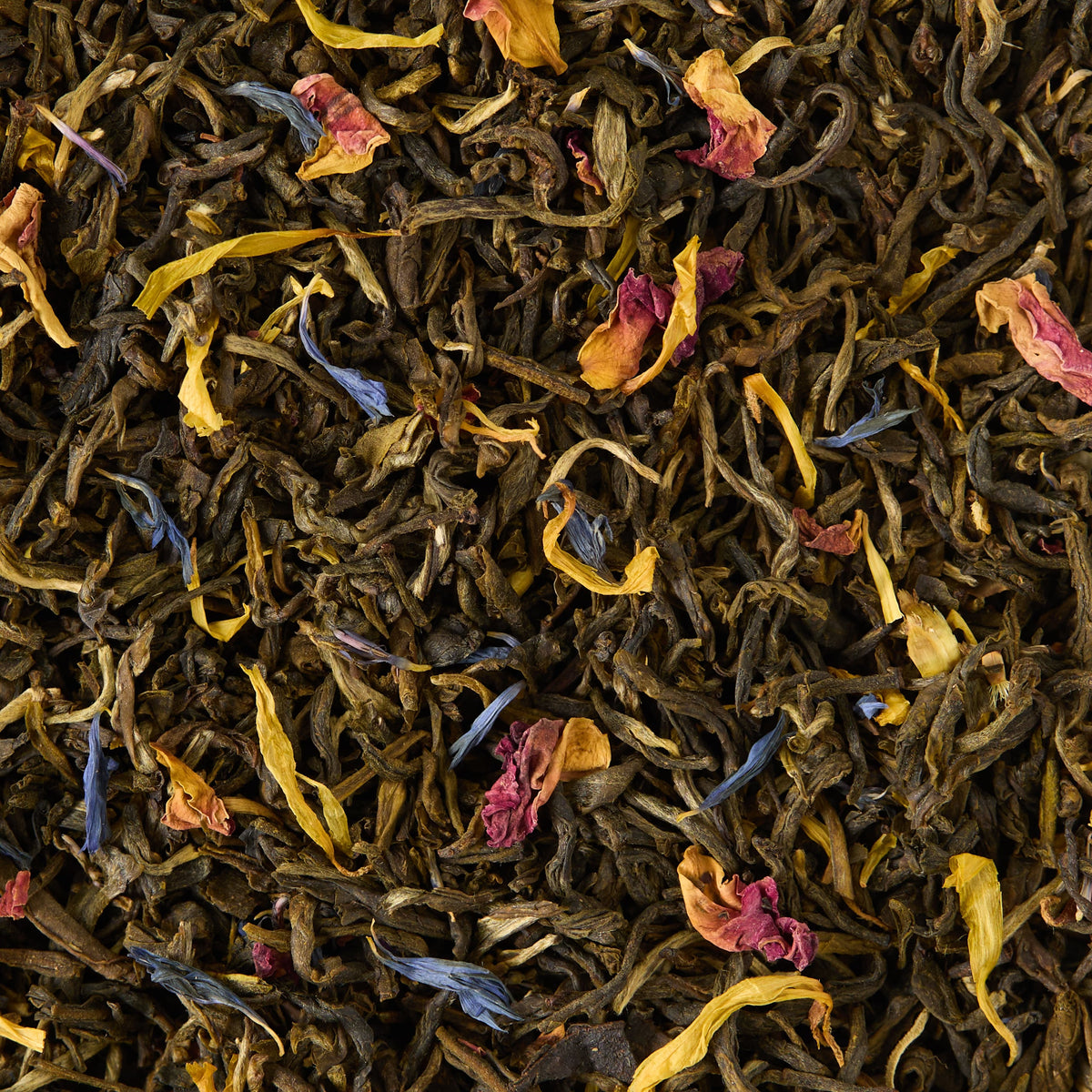 Extravagant Earl Grey Loose Leaf Tea features a blend of loose leaf tea with scattered dried flower petals in yellow, pink, and blue hues. Delicately infused with bergamot, this aromatic white tea offers a vibrant and refreshing experience.