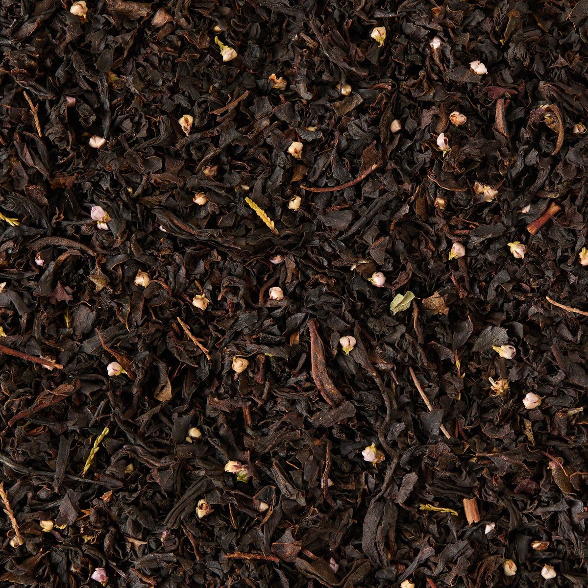 A close-up view of Whisky Loose Leaf Tea, showcasing loose Scottish black tea leaves intermingled with small, light-colored bud fragments and exuding a subtle Scotch whisky aroma, all spread out evenly.