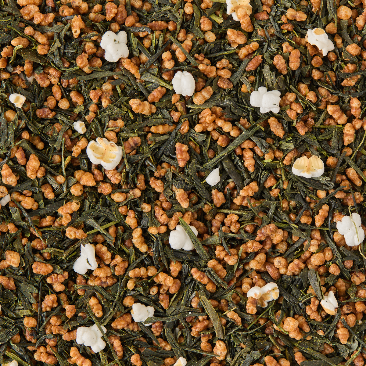 Close-up of Genmaicha Loose Leaf Tea, featuring green tea leaves blended with puffed and roasted brown rice grains for a classic brown rice tea experience.