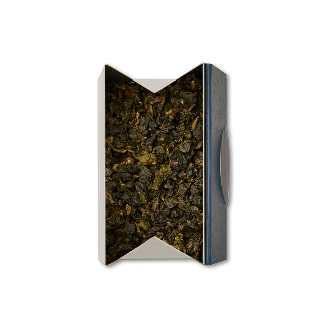 A rectangular, open box filled with Jade Oolong Loose Leaf Tea, its rolled green leaves viewed from above on a white background.