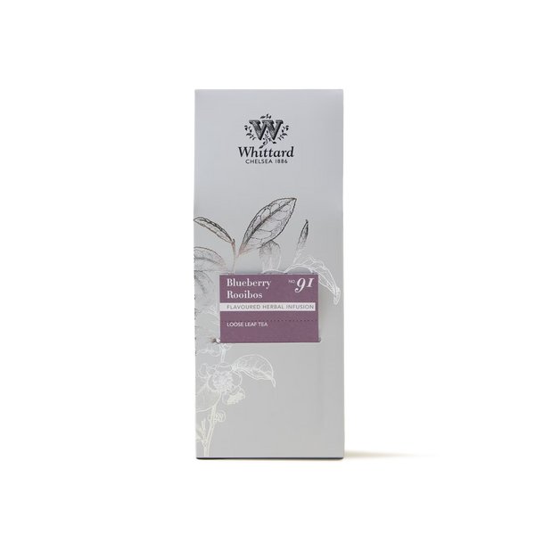A box of Blueberry Rooibos Loose Leaf Tea, elegantly decorated with botanical illustrations on a light grey background. This caffeine-free blend delivers a vibrant and fruity twist to your daily cup.