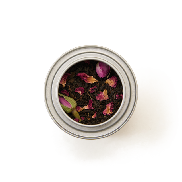 The English Rose Alice in Wonderland Mini Caddy is shown from above, filled with loose leaf tea blended with dried rose petals, set against a white background.