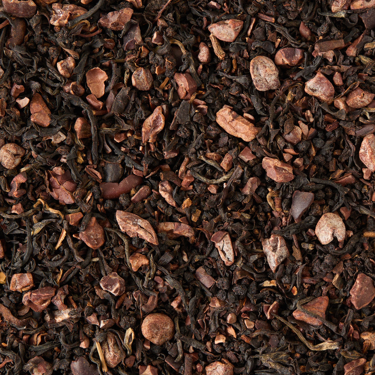 A close-up of Dark Chocolate Loose Leaf Tea blended with cacao nibs, featuring dark brown and black tea leaves contrasted by lighter brown cacao pieces for a textured, natural look.