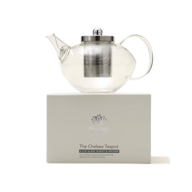 A Chelsea Glass Teapot with Infuser, featuring a clear borosilicate glass body and a metal infuser and lid, is displayed on a white box labeled "The Chelsea Teapot" from Whittard against a plain white background.