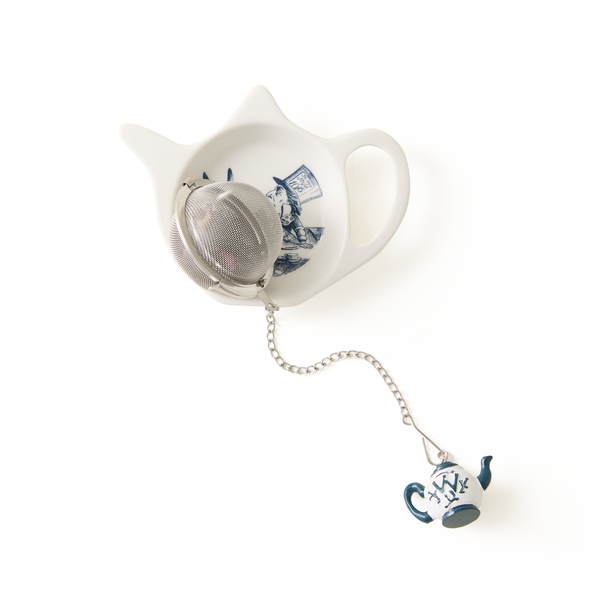 A metal tea infuser with a small teapot charm rests on the Alice in Wonderland Tea Tidy—a white, cat-shaped piece from the Alice Collection, adorned with blue artwork and set against a plain white background.