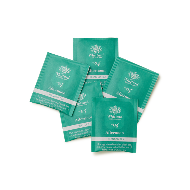 Five green sachets of Tea Discoveries Afternoon Tea 25 Individually Wrapped Teabags are arranged overlapping each other on a plain white background.