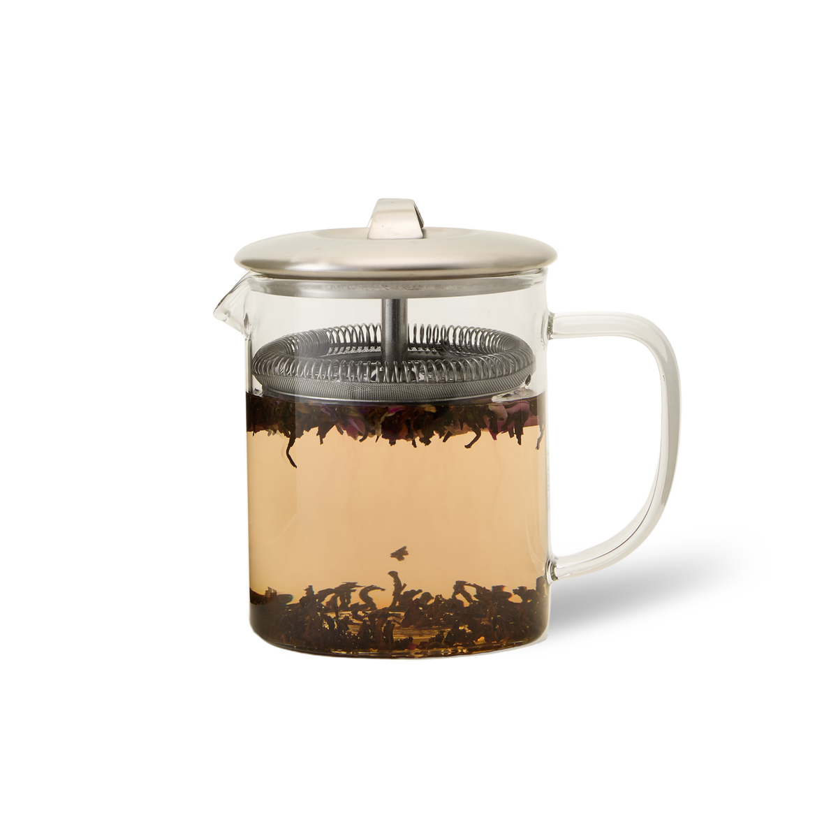 A glass teapot with a metal lid and built-in strainer, filled with light brown tea and loose tea leaves steeping inside, sits on a white background.