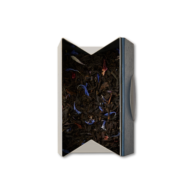 A rectangular open box of Piccadilly Blend Loose Leaf Tea, with visible blue and red flower petals, viewed from above against a white background—perfect for your afternoon brew.