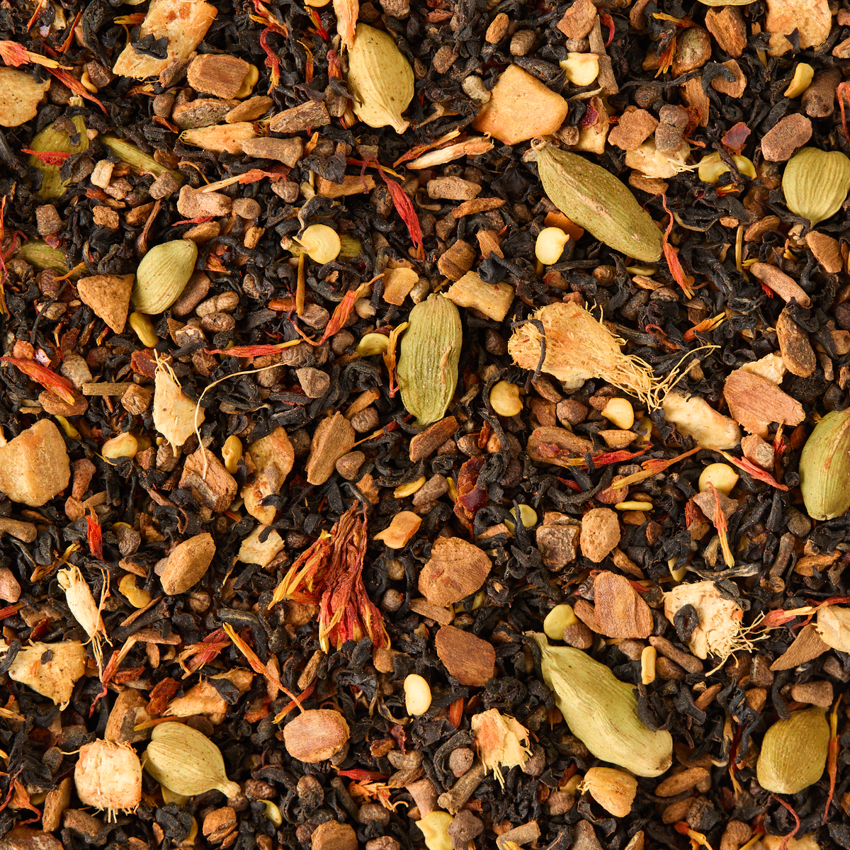 A close-up of Chilli Chai Loose Leaf Tea, featuring black tea leaves blended with whole spices such as cardamom pods, ginger pieces, peppercorns, and other aromatic herbs—ideal for brewing a bold chai latte or savoring as a vibrant, spicy infusion.