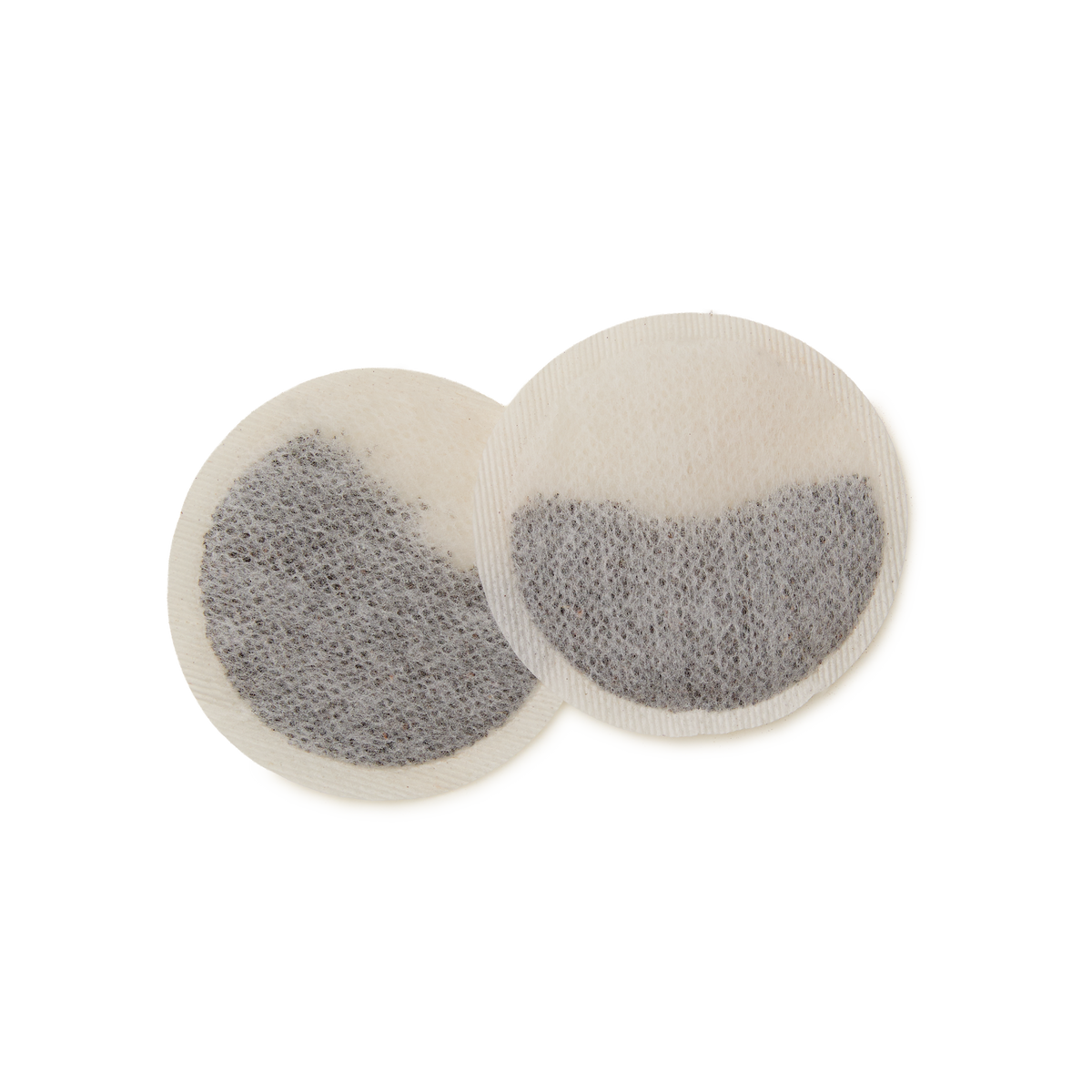 Two round, white Chelsea Breakfast Teabags, filled with visible dark loose tea leaves and overlapping on a plain white background—ideal for steeping a bold cup of this distinctive blend made from select Kenyan and Sri Lankan teas.