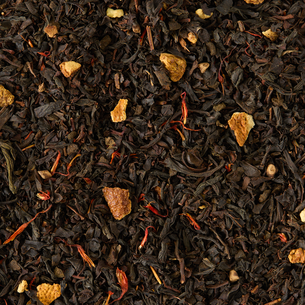 Spice Imperial Loose Leaf Tea features a blend of black tea leaves accented with visible dried orange peel pieces and vibrant red safflower petals. The spiced mix offers a dark, textured appearance highlighted by subtle hints of orange and red.