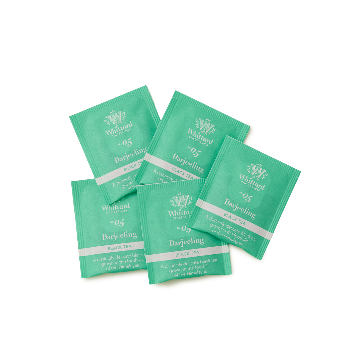 Five green Whittard Darjeeling black tea sachets are spread out on a white background, each labeled 05 Darjeeling with white and silver text.