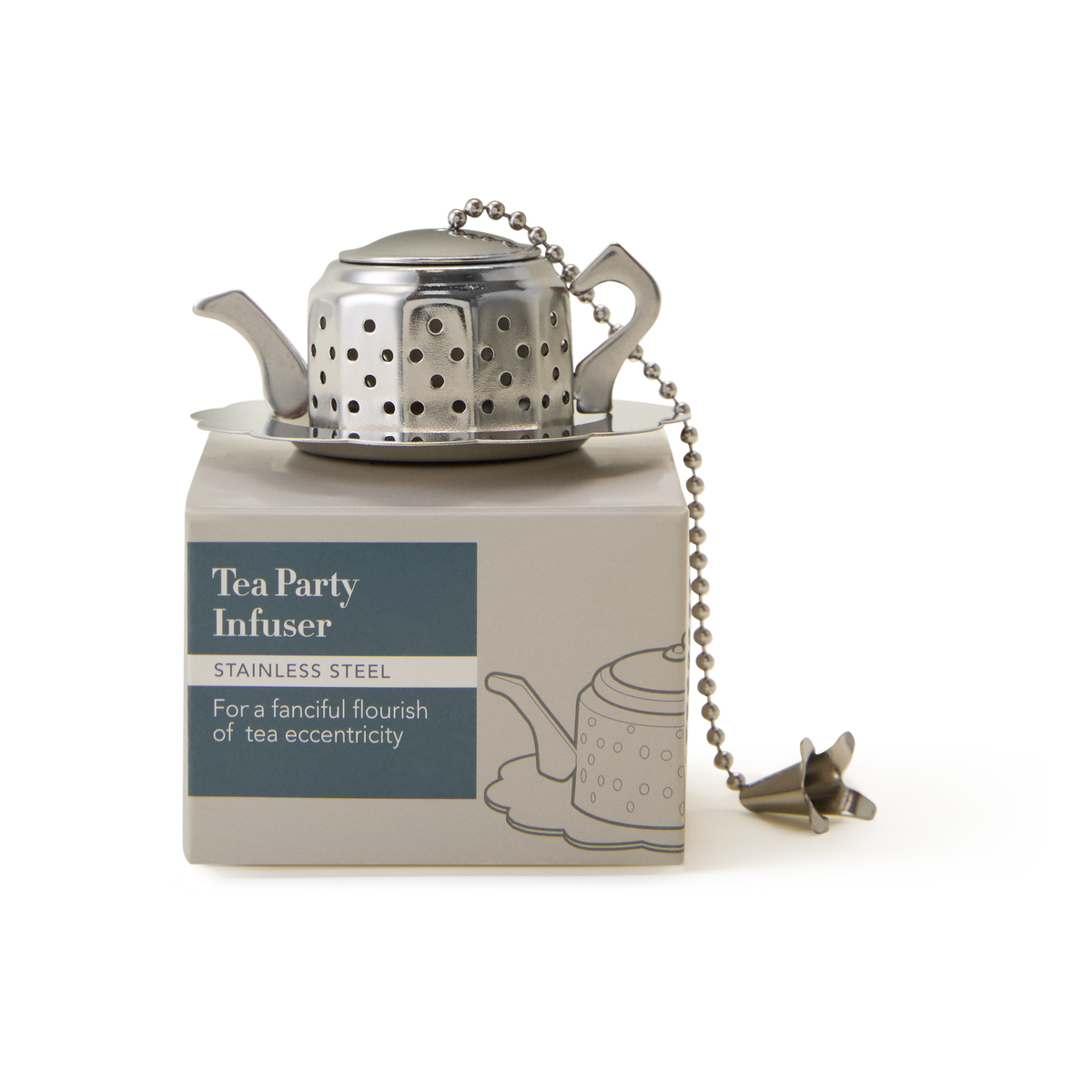 A stainless steel teapot-shaped Tea Party Infuser with a chain sits atop its packaging, which is labeled “Tea Party Infuser: For a fanciful flourish of tea eccentricity—a charming way to steep your favorite loose leaf tea.”.