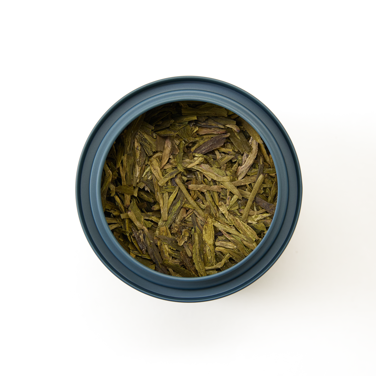 A top-down view of a blue container filled with loose, dried Dragon Well Loose Leaf Tea—renowned as Chinese green tea—on a plain white background.