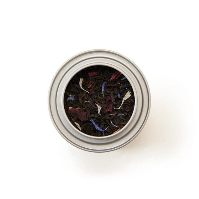 A top view of the Piccadilly Blend Loose Leaf Mini Caddy, a silver tin filled with loose leaf black tea blended with colorful flower petals, creating a vibrant floral tea mix against a white background.