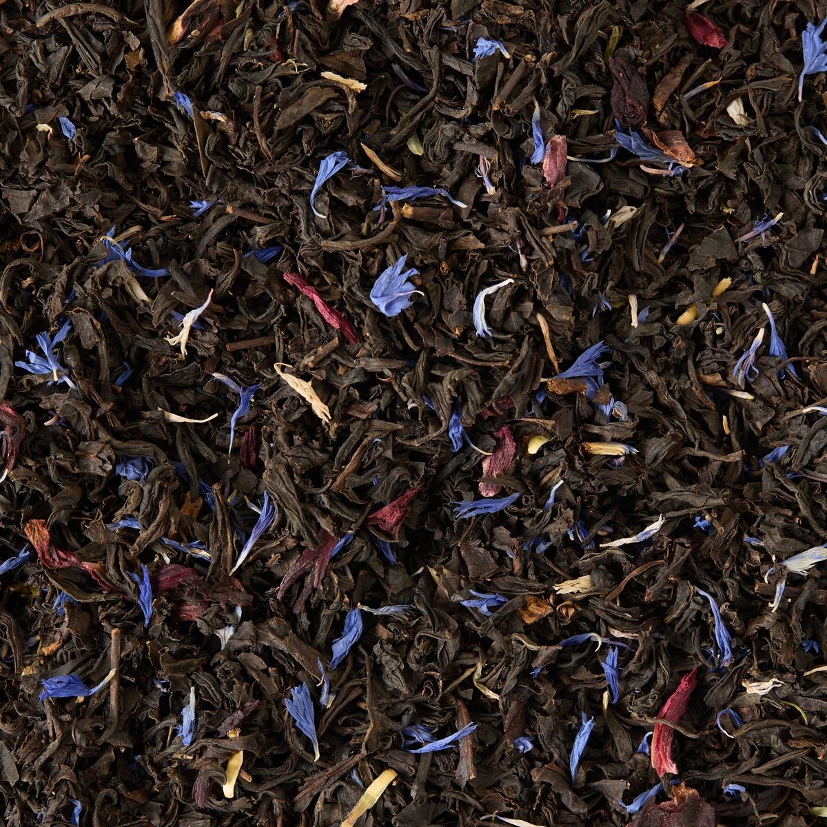 Piccadilly Blend Loose Leaf Mini Caddy features black tea leaves mingled with dried blue, red, and yellow flower petals, creating a vibrant and textured appearance in this exquisite floral tea blend. Ideal as a thoughtful gift, it delights with both its striking visual appeal and rich flavor.