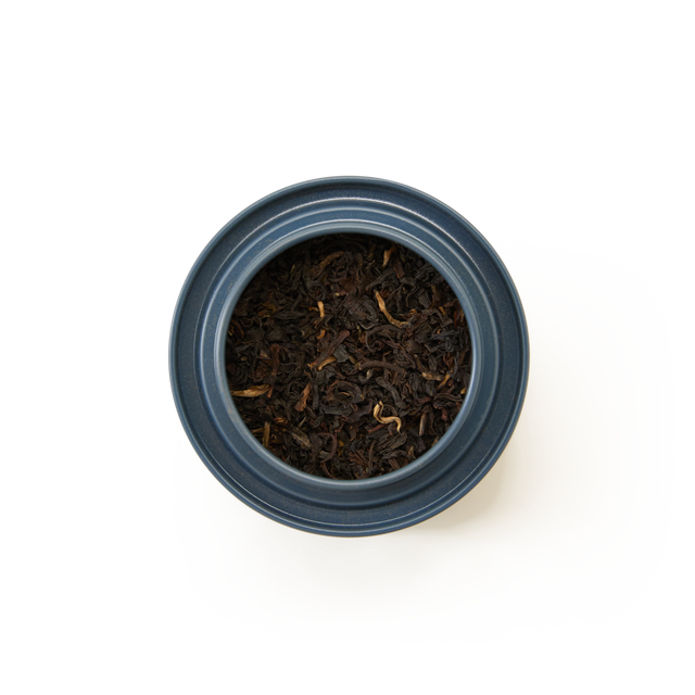 Overhead view of the Chelsea Breakfast Loose Leaf Mini Caddy—a blue jar filled with loose leaf tea—set against a plain white background.