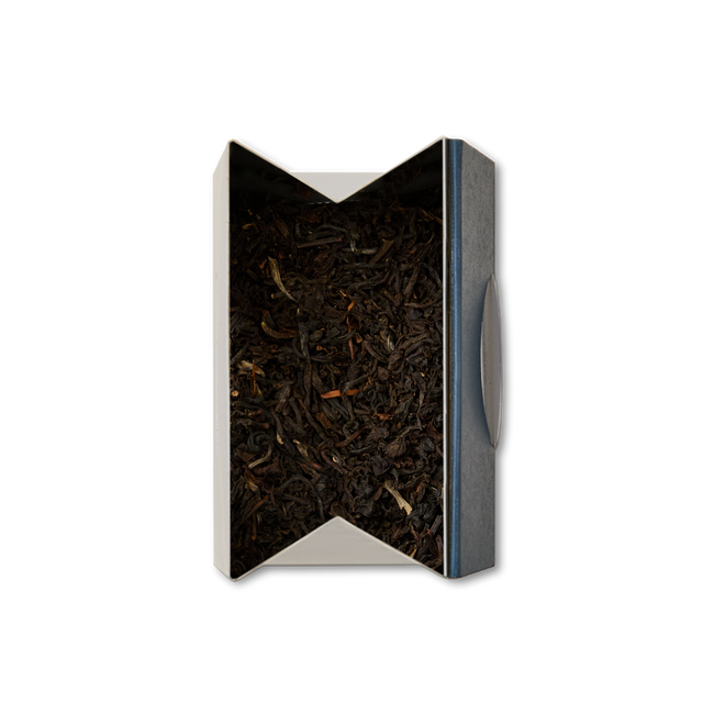 A top-down view of an open, rectangular metal container filled with Chelsea Breakfast Loose Leaf Tea, set against a white background.