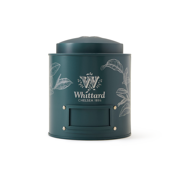 A Fill-Me-Up Blue Caddy with a rich blue finish, featuring white botanical illustrations, a blank label area, and a rounded lid designed for loose leaf tea storage, set against a plain white background.