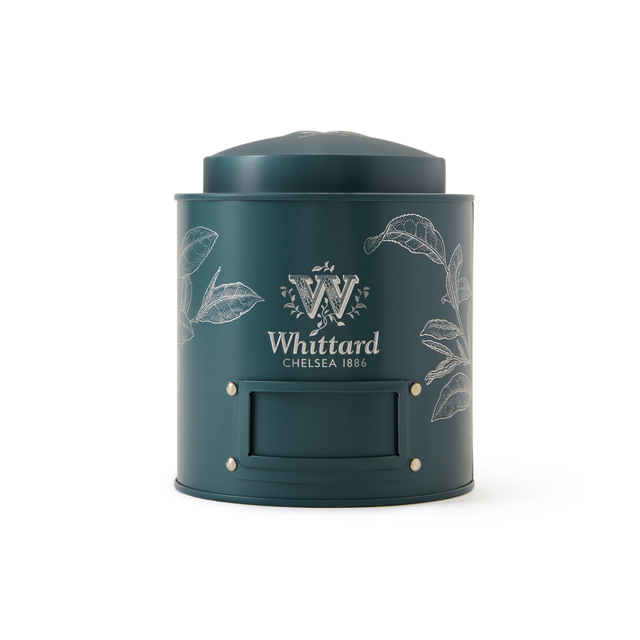 A Fill-Me-Up Blue Caddy with a rich blue finish, featuring white botanical illustrations, a blank label area, and a rounded lid designed for loose leaf tea storage, set against a plain white background.