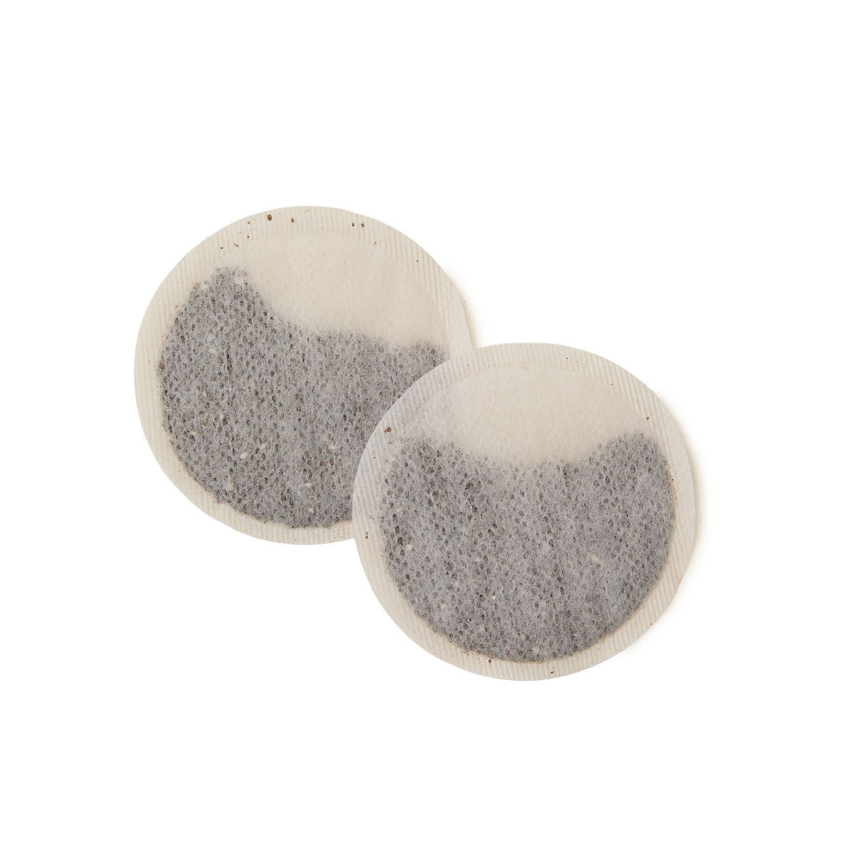 Two round, flat English Rose Teabags filled with loose tea leaves, overlapping slightly on a white background.
