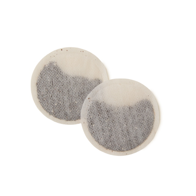 Two round, flat English Rose Teabags filled with loose tea leaves, overlapping slightly on a white background.