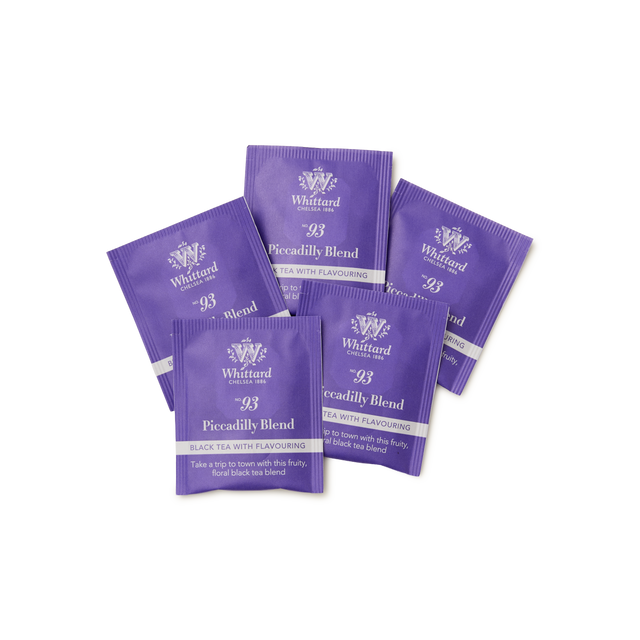 Five purple tea sachets labeled Whittard 93 Piccadilly Blend Black Tea with Flavouring are arranged in a fan shape on a white background.