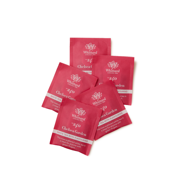 Five red tea sachets labeled Whittard Chelsea Garden are arranged in a scattered pile on a white background.
