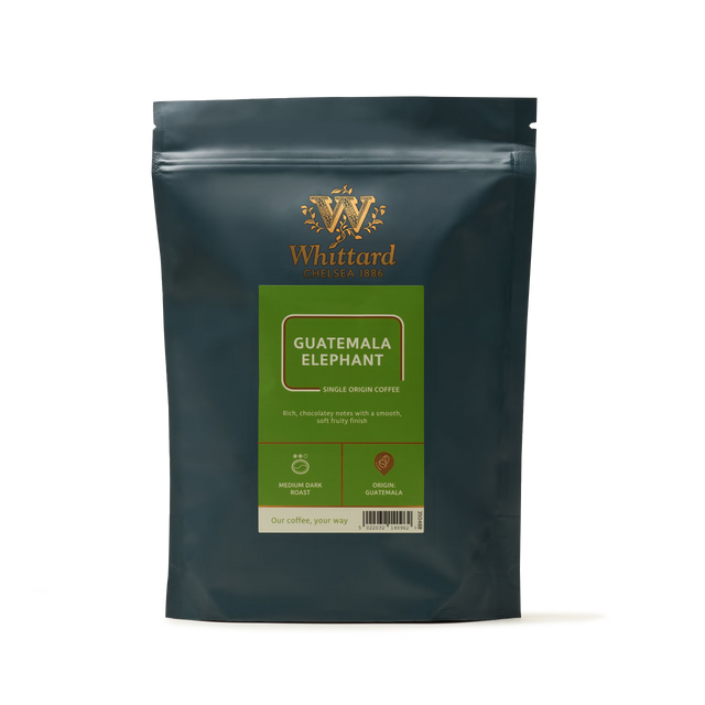 A dark packet of Whittard Guatemala Elephant Coffee features gold and green labels showcasing product details and coffee origin information on the front. Crafted from large, volcanic coffee beans sourced from Guatemala, this single origin coffee offers a bold and distinctive flavor profile.