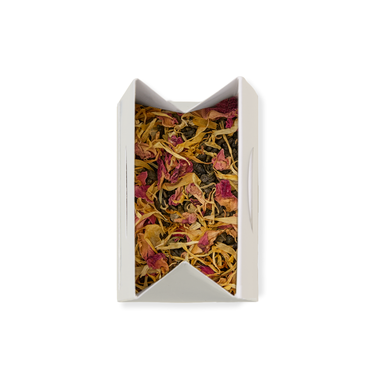 A white rectangular box filled with Passionfruit & Mango Loose Leaf Tea, showcasing a vibrant blend of dried tea leaves and colorful flower petals—yellow and pink—viewed from above against a plain white background. This inviting display highlights the premium loose leaf green tea, perfect for tea lovers.