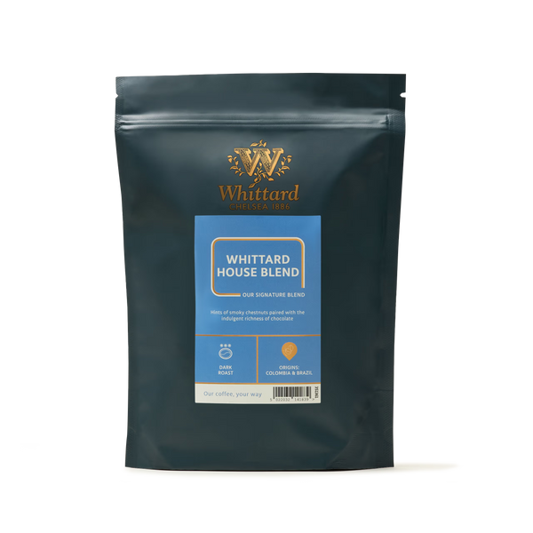 A dark teal bag of Whittard House Blend Coffee, adorned with gold and blue accents and prominent Whittard branding along with blend details on the front, stands upright against a white background. This house blend combines Brazilian and Colombian coffees for a rich, balanced flavor.