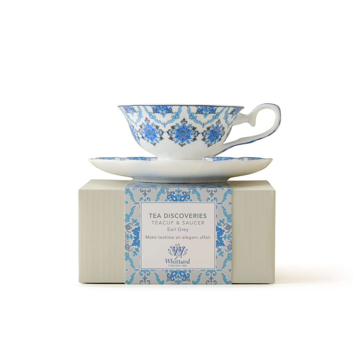 A blue and white patterned teacup and saucer sit atop a matching box labeled Tea Discoveries Teacup & Saucer Earl Grey by Whittard of Chelsea, on a plain white background.