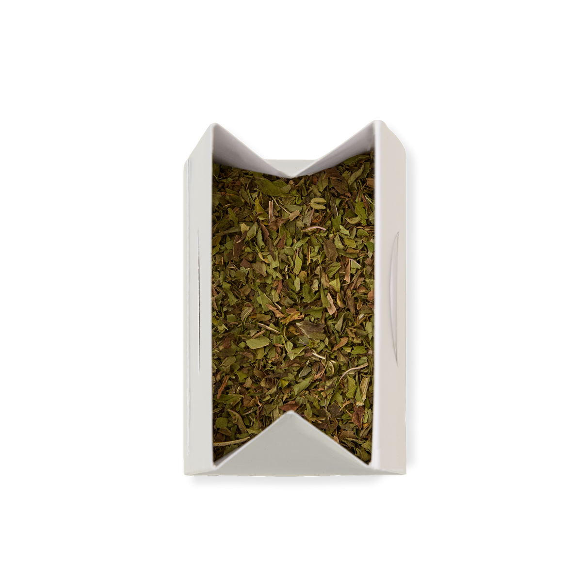 A white, rectangular container filled with Peppermint Loose Infusion—dried, chopped green herbs—is viewed from above against a plain white background.