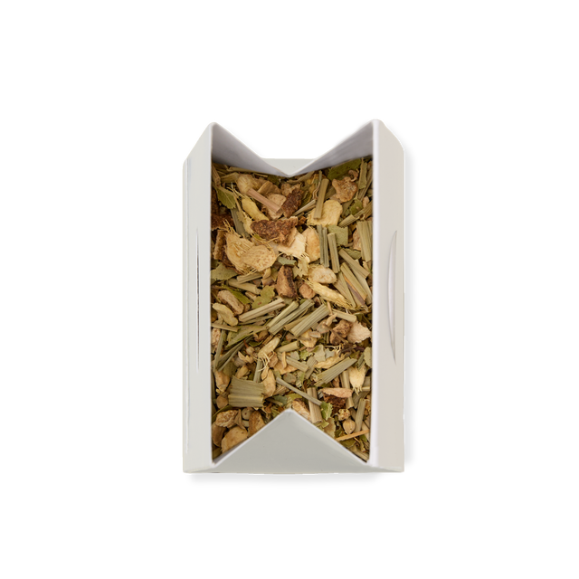 A top-down view of a white rectangular box filled with Lemon & Ginger Loose Infusion, showcasing a blend of green and brown dried herbs and plant pieces, set against a plain white background.