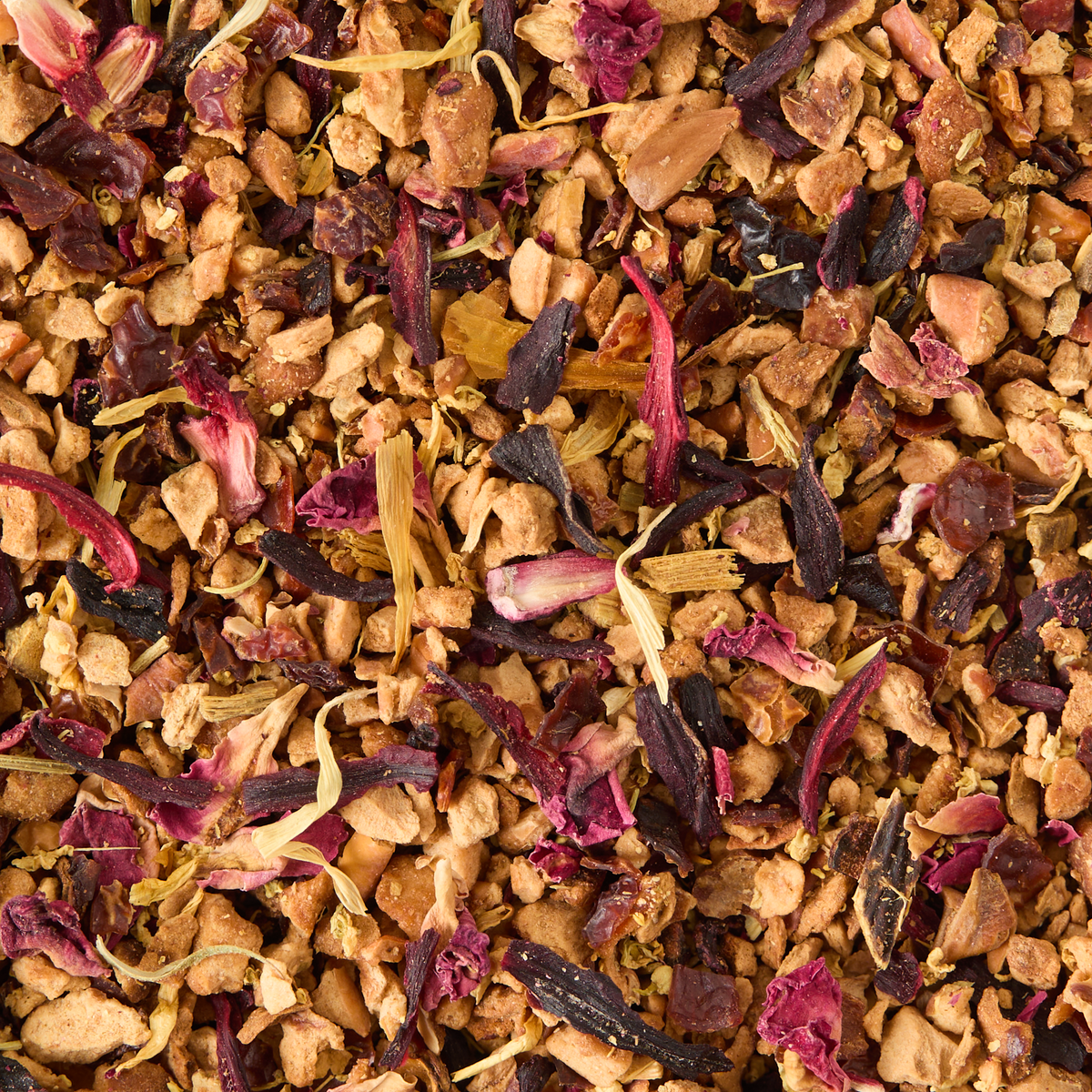 A close-up of Elderflower & Apple Loose Infusion, featuring a vibrant blend of dried fruit pieces, petals, and herbs in shades of brown, pink, purple, and yellow for a colorful, textured mixture.