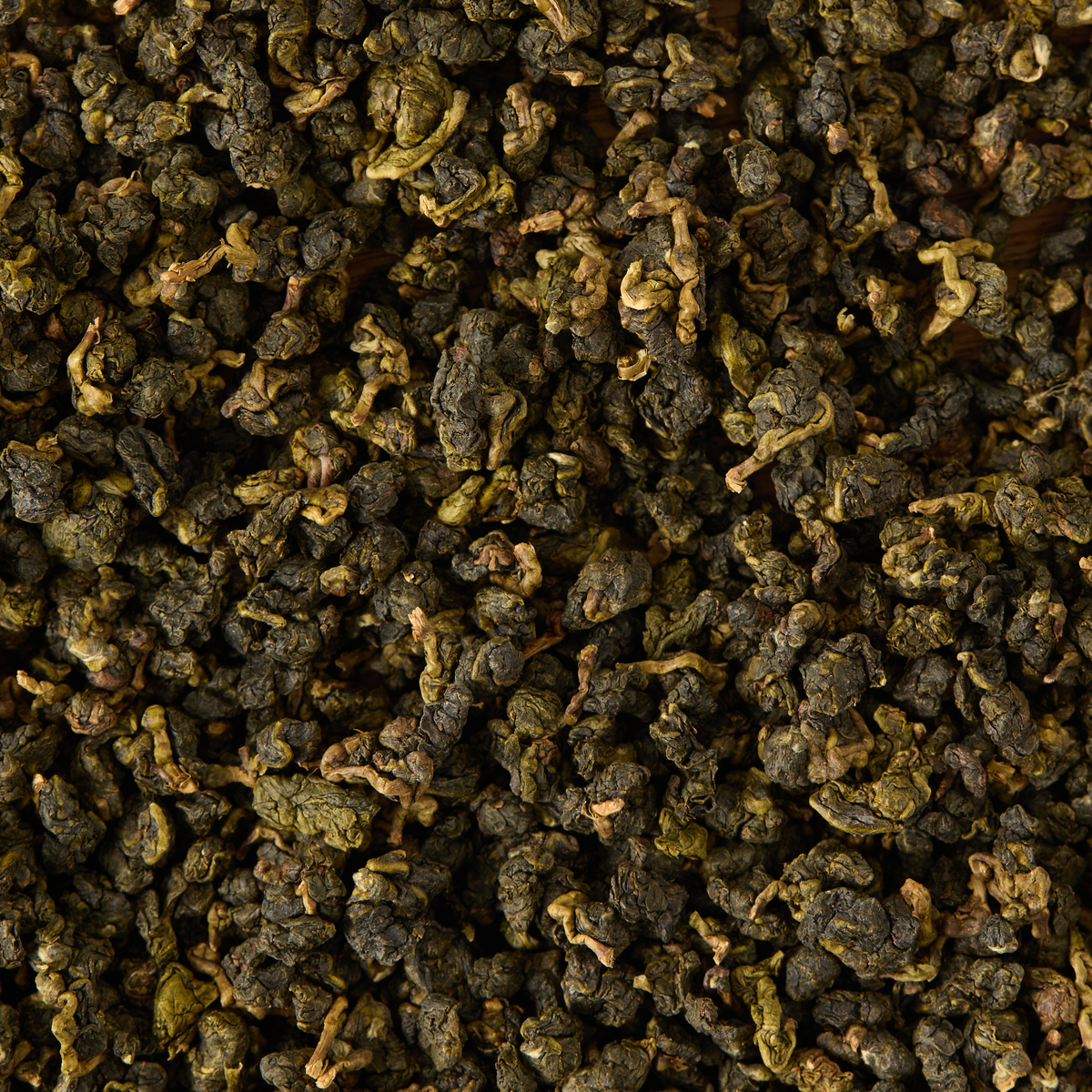 A close-up view of rolled, dried Milk Oolong Loose Leaf Tea leaves creates a textured, earthy pattern across the image.
