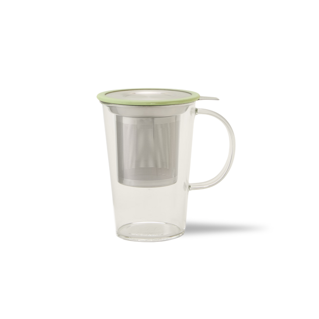 A clear glass mug with a handle, containing a metal tea infuser and topped with a light green lid, set against a plain white background.