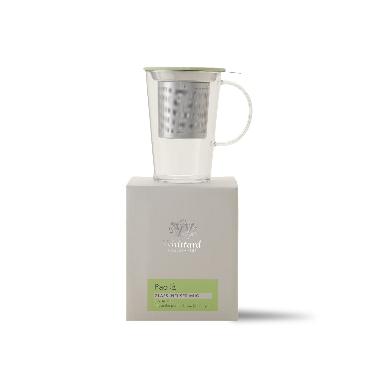 A clear glass infuser mug with a metal strainer and a light green lid, placed on top of a white Whittard Pao packaging box.