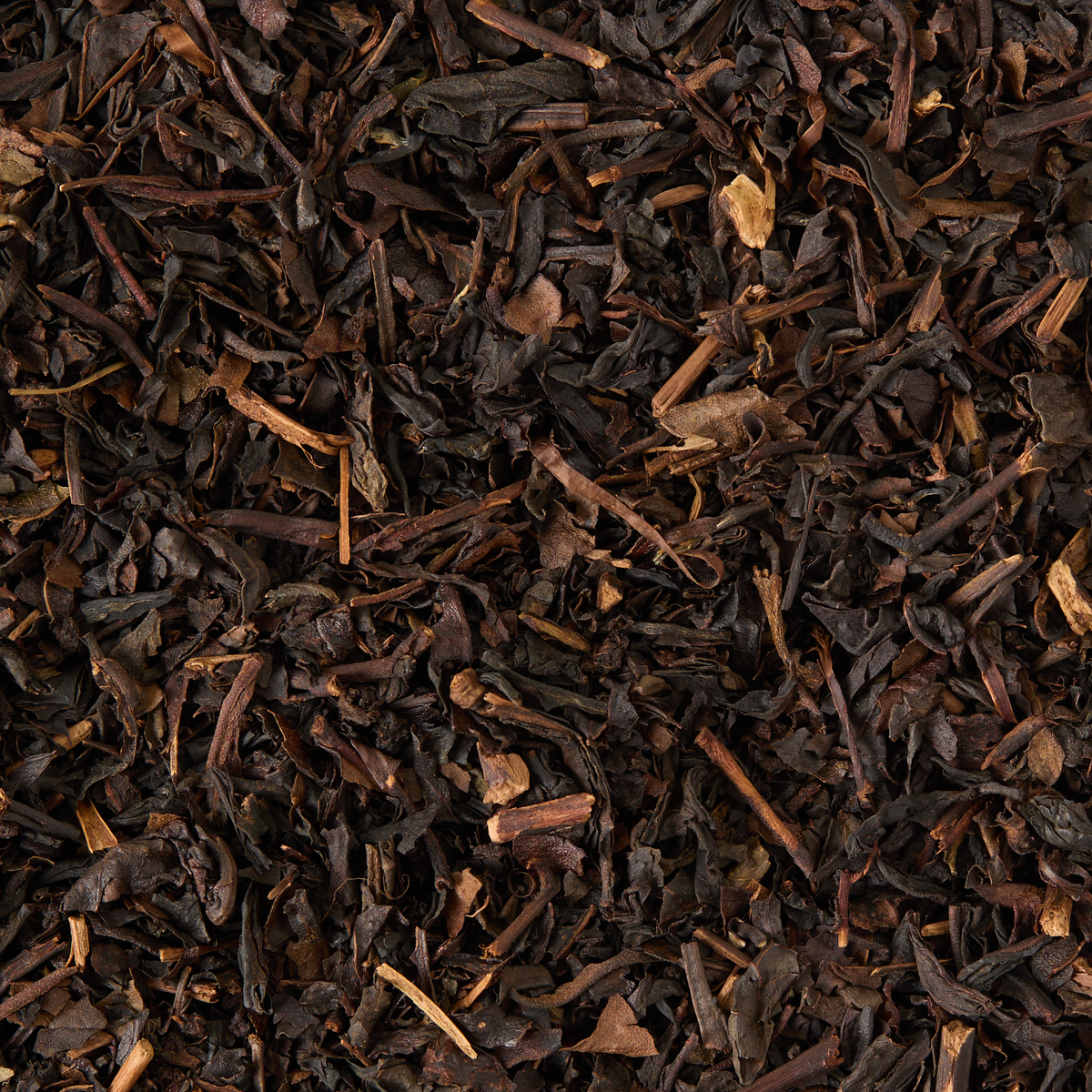 A close-up view of Peach Oolong Loose Leaf Tea, highlighting its dark brown and black curled and broken textures that are characteristic of high-quality oolong leaves.