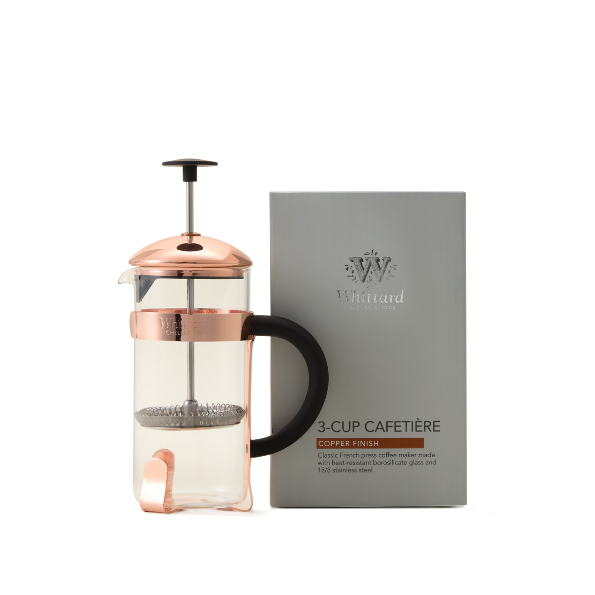 A Whittard Copper 3-Cup Cafetière, featuring a black handle, a durable borosilicate glass body, and a stainless steel filter, is placed next to its silver box labeled Whittard 3-Cup Cafetière.