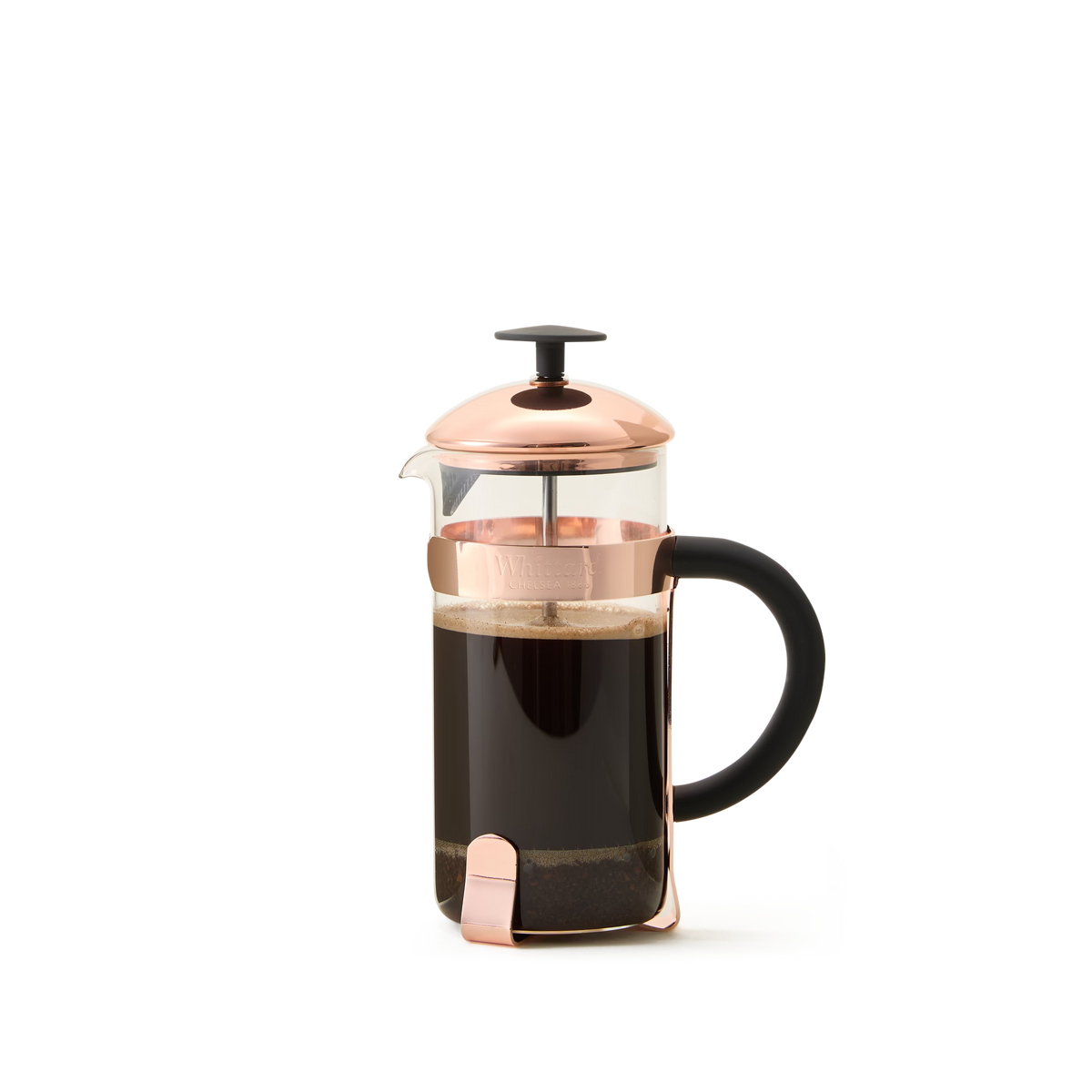 The Whittard Copper 3-Cup Cafetière, featuring a borosilicate glass body with a copper lid and handle, sits on a white background filled with brewed coffee and grounds at the bottom. This elegant cafetière includes a durable stainless steel filter for smooth, rich flavor in every cup.