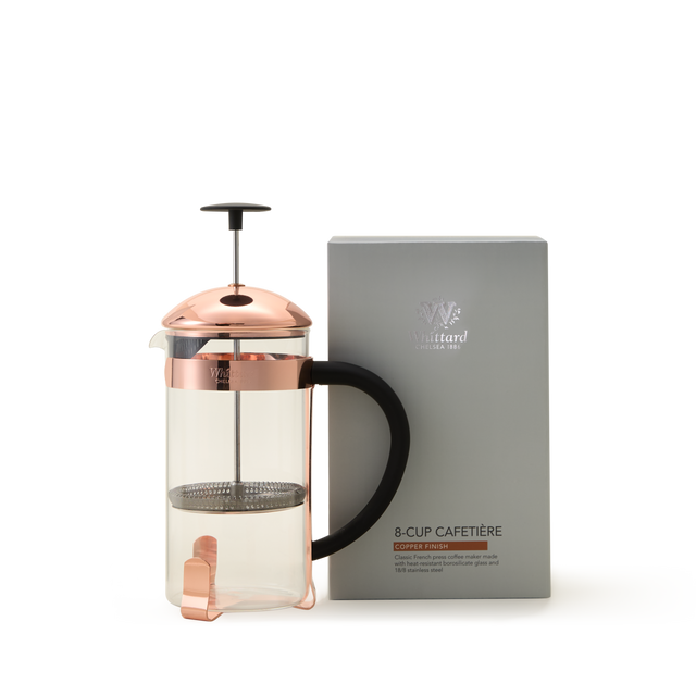 A glass French press made from durable borosilicate glass with a copper lid and handle sits next to a gray box labeled Whittard Copper 8-Cup Cafetière.