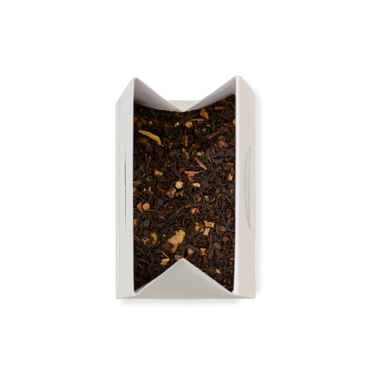 A white rectangular box of Spiced Chai Loose Leaf Tea, containing black tea and small pieces of herbs, viewed from above against a plain white background.