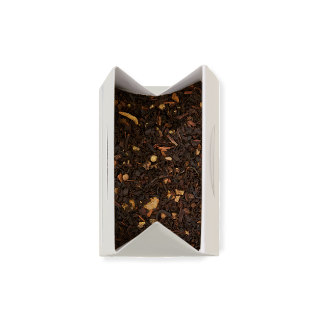 A white rectangular box of Spiced Chai Loose Leaf Tea, containing black tea and small pieces of herbs, viewed from above against a plain white background.