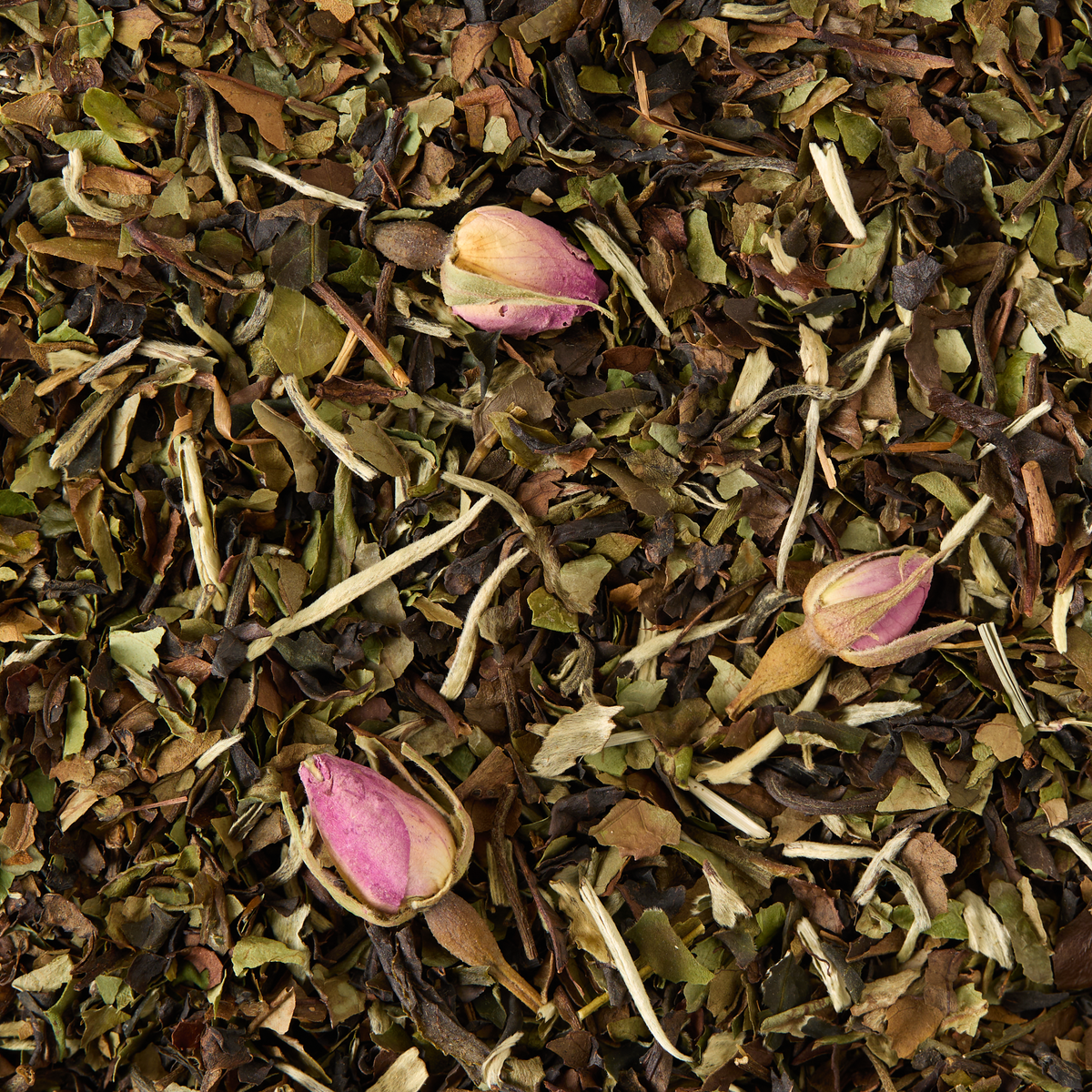 Chelsea Garden Loose Leaf Tea features a blend of dried green leaves and three small pink rosebuds delicately scattered on top. The combination of varied textures and soft colors gives it a natural, botanical look reminiscent of White Peony white tea.